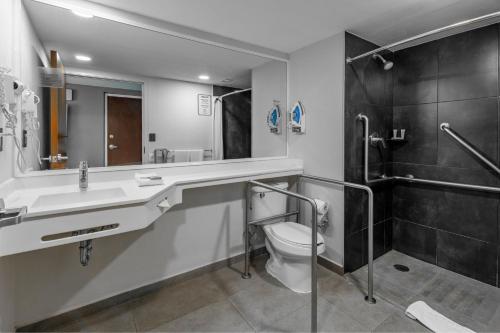 a bathroom with a toilet and a sink and a shower at City Express by Marriott Chetumal in Chetumal