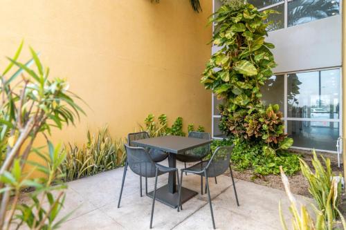 a table and chairs in front of a building at City Express by Marriott Chetumal in Chetumal
