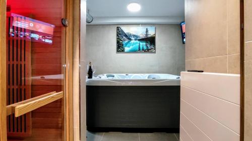 a bathroom with a bath tub and a mirror at GRAND SPA Harrachov - Wellness luxusní apartmán s velkou vířivkou, saunou, kuchyní a venkovním posezením v centru Harrachova in Harrachov