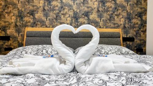 two swans making a heart shape on a bed at GRAND SPA Harrachov - Wellness luxusní apartmán s velkou vířivkou, saunou, kuchyní a venkovním posezením v centru Harrachova in Harrachov