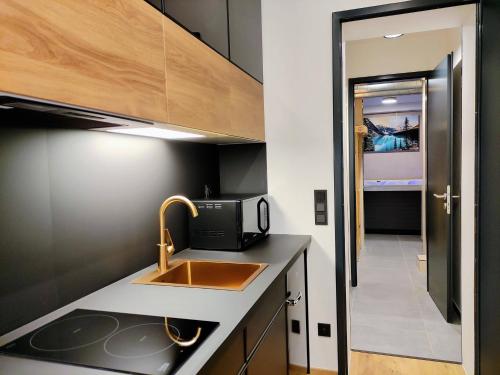 a kitchen with a sink and a microwave at GRAND SPA Harrachov - Wellness luxusní apartmán s velkou vířivkou, saunou, kuchyní a venkovním posezením v centru Harrachova in Harrachov
