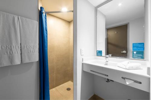 a bathroom with a sink and a mirror at City Express Junior by Marriott Merida Altabrisa in Mérida