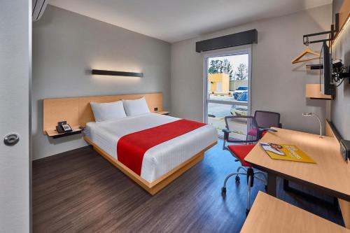 a hotel room with a bed and a desk and a desk at City Express by Marriott Celaya Galerias in Celaya