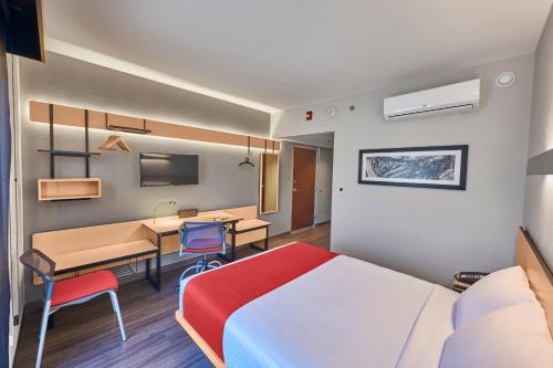 a hotel room with a bed and a desk and a table at City Express by Marriott Celaya Galerias in Celaya