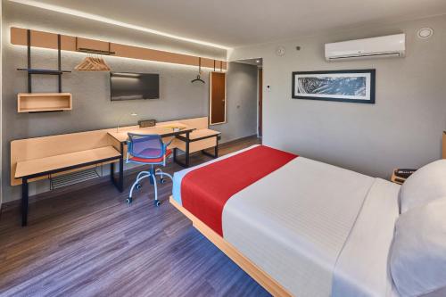 a hotel room with a bed and a desk at City Express by Marriott Celaya Galerias in Celaya