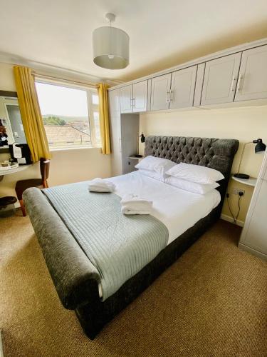 a bedroom with a large bed with a large window at Villa Mentone Hotel in Shanklin