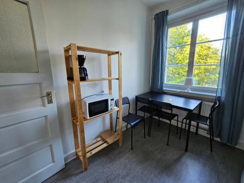 Kleines Zimmer mit einem Tisch und einer Mikrowelle. in der Unterkunft Home Inn RSG19 in Stockholm
