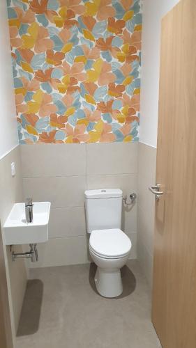 a bathroom with a toilet and a painting on the wall at Bloom Hostel Bar & Garden in Bordeaux