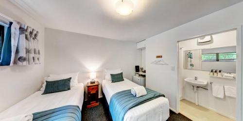 two beds in a small room with a sink at Lochmara Lodge in Lochmara Bay