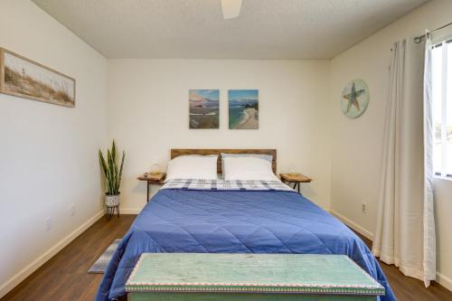 a bedroom with a bed with a blue comforter at Pet-Friendly Santa Maria Condo with Balcony! in Santa Maria