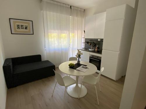 ein kleines Wohnzimmer mit einem weißen Tisch und Stühlen in der Unterkunft Casettadellafotografia in Senigallia