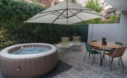 a patio with a hot tub and a table and an umbrella at VELVET HOME Pescara - Luxury Apartment in Pescara