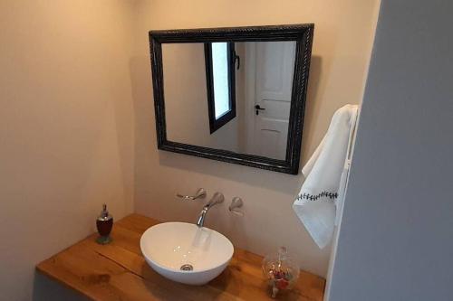 uma casa de banho com um lavatório e um espelho num balcão em Espacio en Tres Arroyos em Tres Arroyos