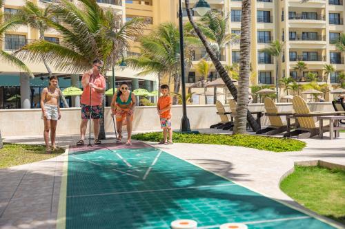 a group of people standing next to a swimming pool at The Royal Sands Resort & Spa in Cancún