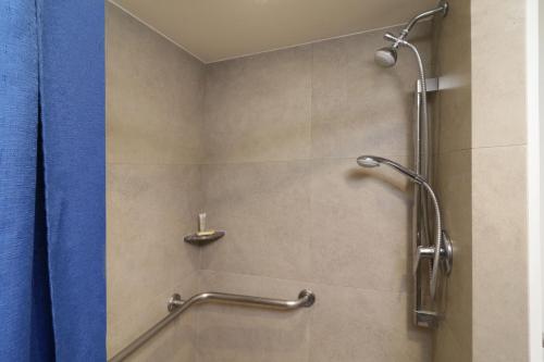 a bathroom with a shower with a blue shower curtain at City Express Junior by Marriott San Luis Potosi Zona Industrial in San Luis Potosí