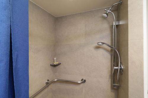 a bathroom with a shower with a blue shower curtain at City Express Junior by Marriott San Luis Potosi Zona Industrial in San Luis Potosí