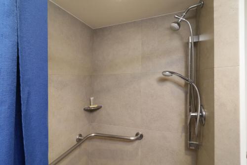 La salle de bains est pourvue d'une douche avec un rideau de douche bleu. dans l'établissement City Express Junior by Marriott San Luis Potosi Zona Industrial, à San Luis Potosí