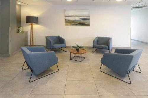 a waiting room with three chairs and a table at City Express by Marriott Tijuana Insurgentes in Tijuana