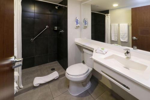 a bathroom with a toilet and a sink and a shower at City Express by Marriott Tijuana Insurgentes in Tijuana