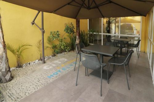 a restaurant with tables and chairs and an umbrella at City Express by Marriott Tijuana Insurgentes in Tijuana