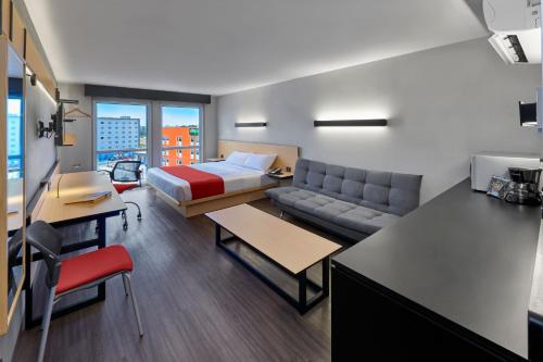 une chambre d'hôtel avec un lit et un canapé dans l'établissement City Express by Marriott Tijuana Otay, à Tijuana