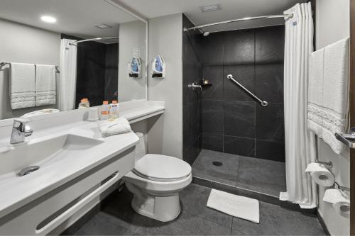 uma casa de banho com um WC com lavatório e um chuveiro em City Express by Marriott Tijuana Otay em Tijuana