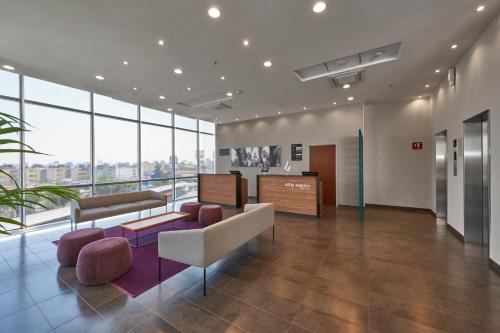 an office lobby with a waiting area and windows at City Express by Marriott La Raza in Mexico City