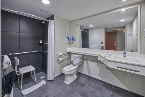 a bathroom with a sink and a toilet and a tub at City Express by Marriott Salamanca in Salamanca