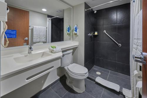 a bathroom with a toilet and a sink and a shower at City Express by Marriott Salamanca in Salamanca