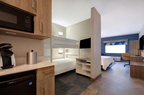 a room with a kitchen and a bedroom with a bed at Holiday Inn Express Hotel & Suites Moab, an IHG Hotel in Moab