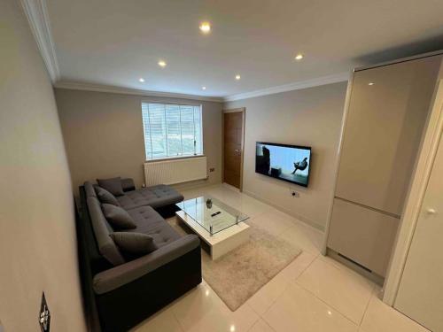 - un salon avec un canapé et une télévision dans l'établissement Charming 1-Bedroom Retreat for up to 4 Guests, à Windsor