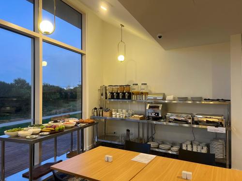 a kitchen with two tables and a counter with food at Manha Hotel Auckland Airport in Auckland