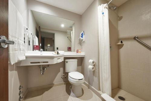 a bathroom with a toilet and a sink and a shower at City Express Suites by Marriott Tijuana Rio in Tijuana