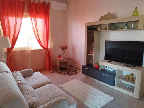 salon z kanapą i telewizorem z płaskim ekranem w obiekcie Casa Circe w mieście San Felice Circeo