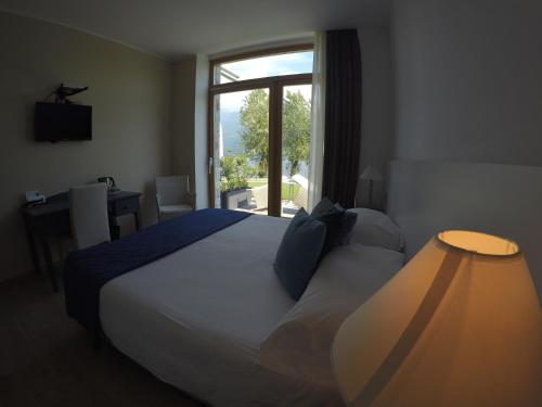 a bedroom with a large bed and a window at Tullio Hotel in Gravedona