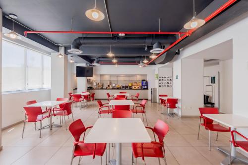 a dining room with white tables and red chairs at City Express Junior by Marriott Villahermosa in Villahermosa