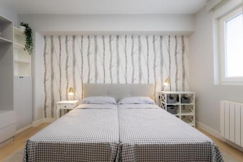 a bedroom with a bed with a checkered blanket at Apartamento tranquilo y céntrico en Santander in Santander