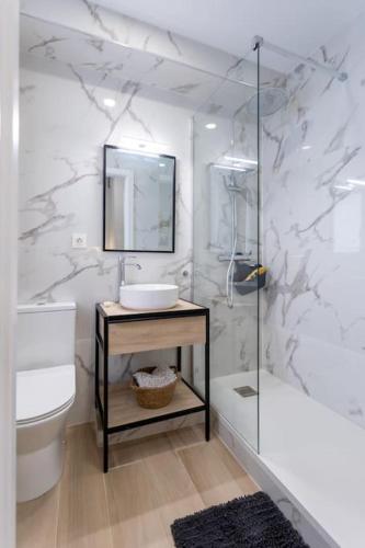 a white bathroom with a sink and a mirror at Apartamento tranquilo y céntrico en Santander in Santander