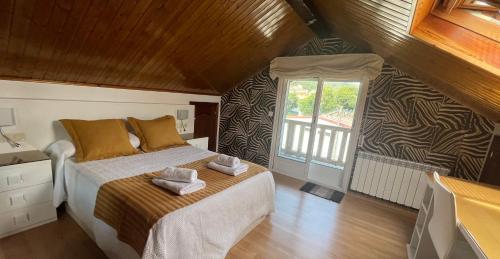 1 dormitorio con 1 cama con 2 toallas en Loira ático con vistas al mar, en Poio