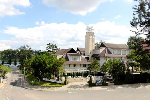 a large white house with a tower on top of it at Muong Thanh Holiday Da Lat Hotel in Da Lat