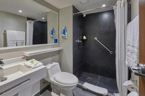 a bathroom with a toilet and a shower at City Express by Marriott Hermosillo Expo in Hermosillo