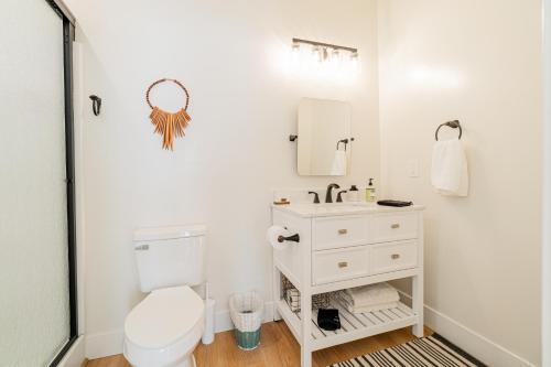 y baño con aseo blanco y lavamanos. en Reno Dream Cottage: Delightful 2-Bedroom Sanctuary, en Reno
