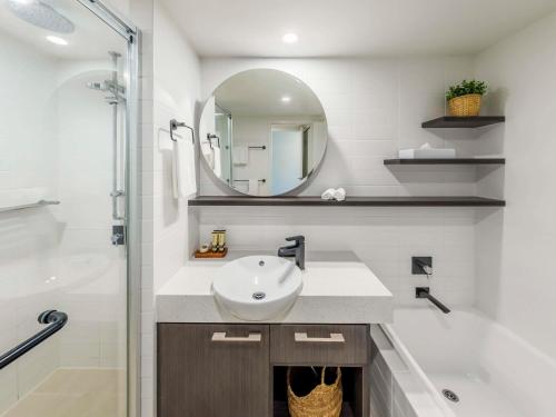 ein Bad mit einem Waschbecken und einem Spiegel in der Unterkunft The Sebel Palm Cove in Palm Cove