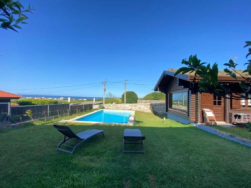 a yard with two chairs and a swimming pool at Encantadora moradia T1, com piscina e vista mar a 500m da praia in Viana do Castelo