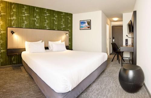 Cette chambre comprend un grand lit et un bureau. dans l'établissement Best Western Hotel Wavre, à Wavre