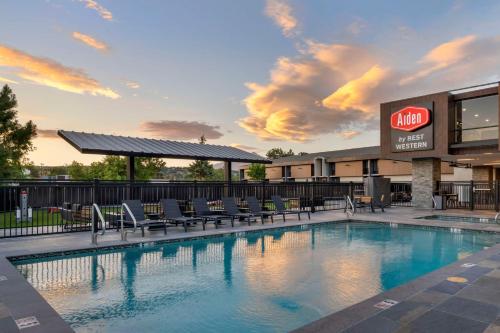 a swimming pool with chairs and a building at Aiden by Best Western Flagstaff in Flagstaff