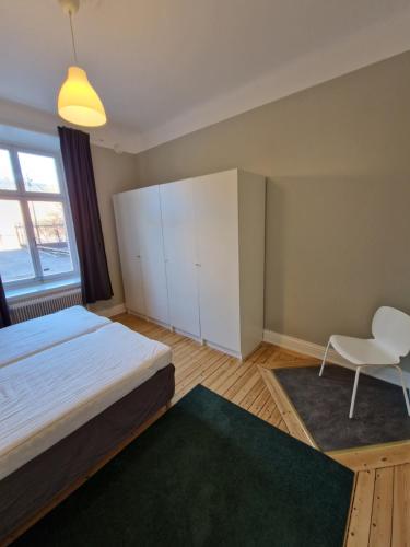 ein Schlafzimmer mit einem Bett und einem Stuhl darin in der Unterkunft Home Inn UPG76 in Stockholm