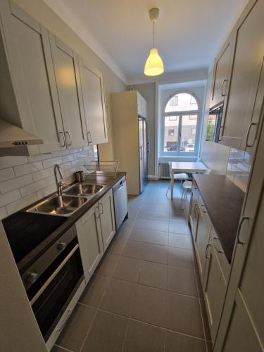 eine Küche mit weißen Schränken und einem Waschbecken in der Unterkunft Home Inn UPG76 in Stockholm