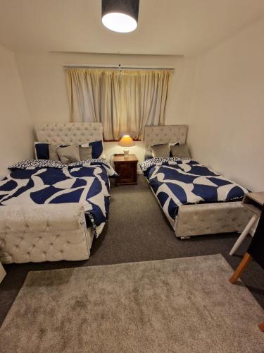 a bedroom with two beds and a table with a lamp at Millmead Apartment in central Guildford with parking in Guildford