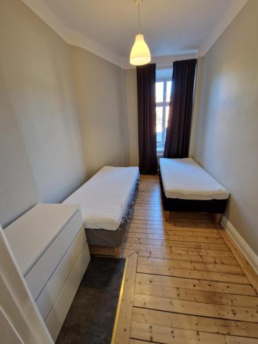 a room with two beds and a window at Home Inn UPG76 in Stockholm